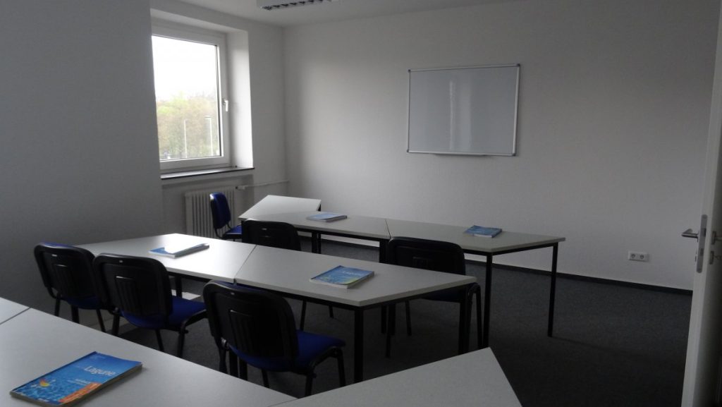 A classroom featuring several tables and chairs arranged for student use.