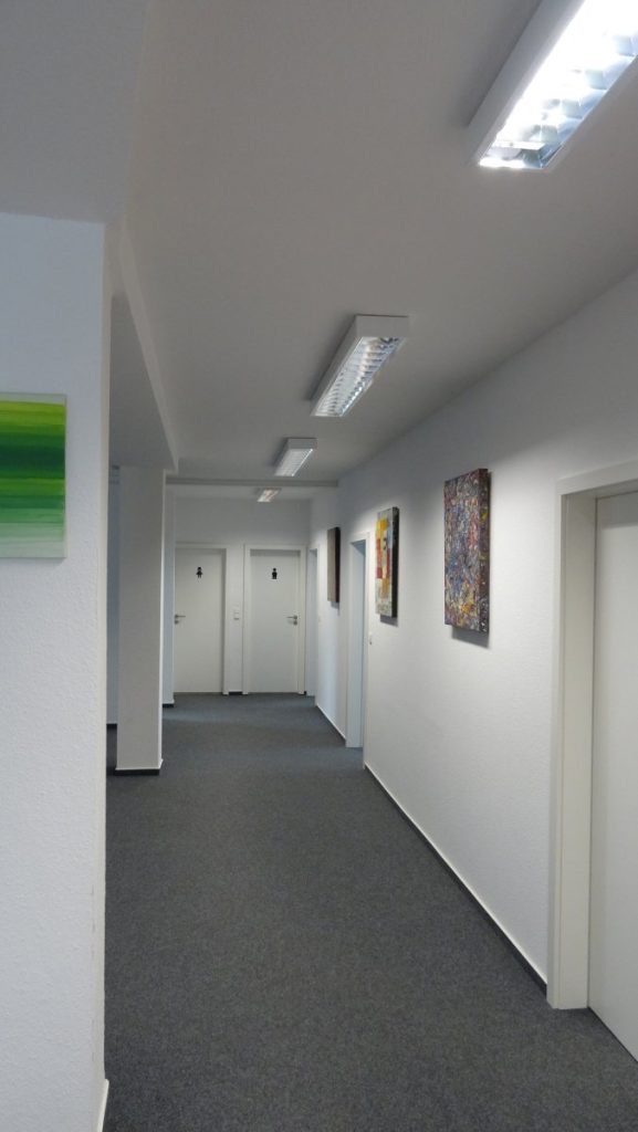 A long hallway adorned with various paintings lining the walls, creating an artistic atmosphere.