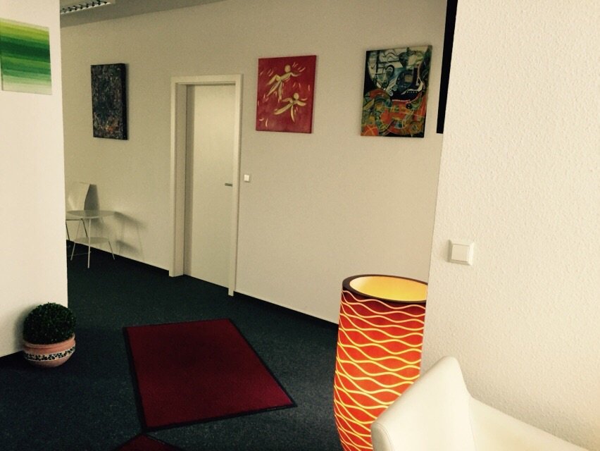 A hallway featuring a red rug and several paintings adorning the walls, creating a warm and inviting atmosphere.