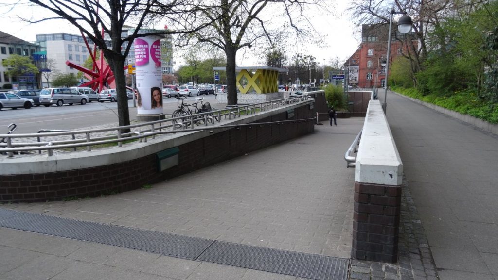  A sidewalk featuring a bench and a railing, providing a resting spot along the pathway.